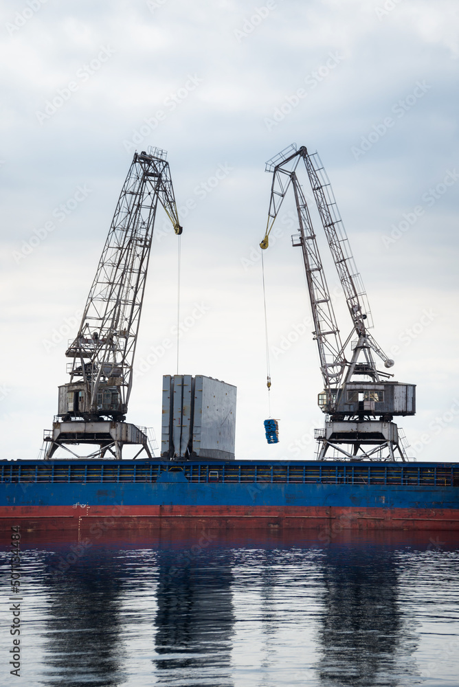  Cranes at cargo terminal in  docking station loading cargo ship