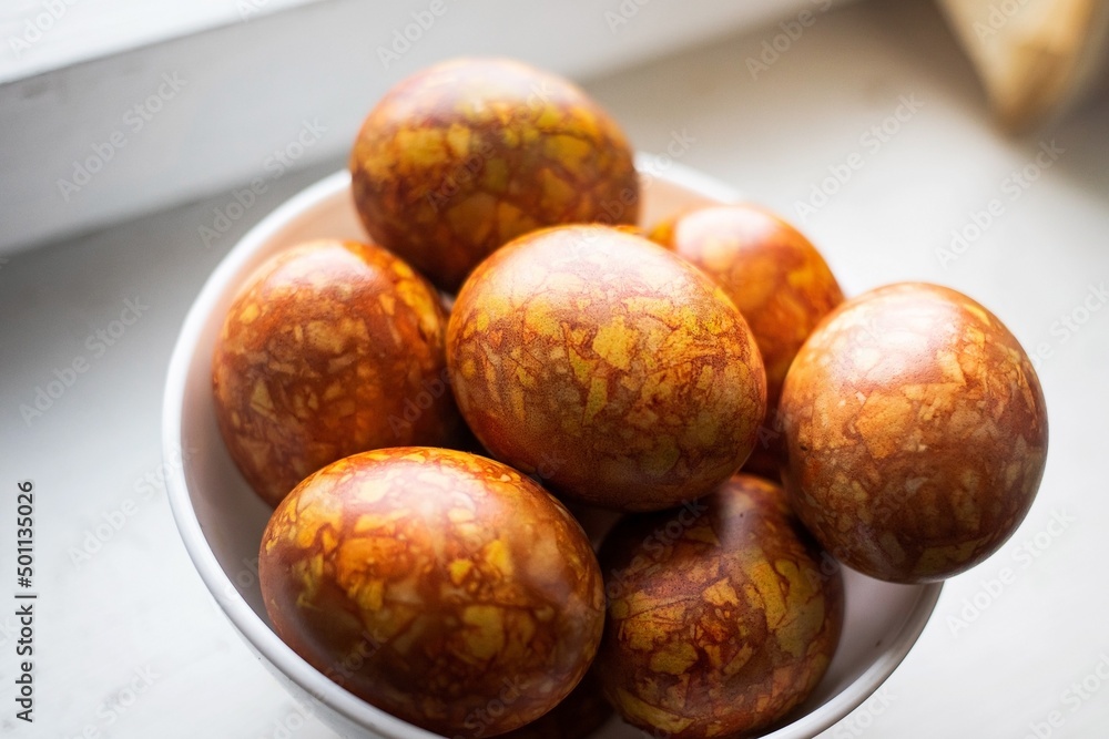 Obraz premium colored colorful chicken eggs in a large white plate as a symbol of the national holiday of believers