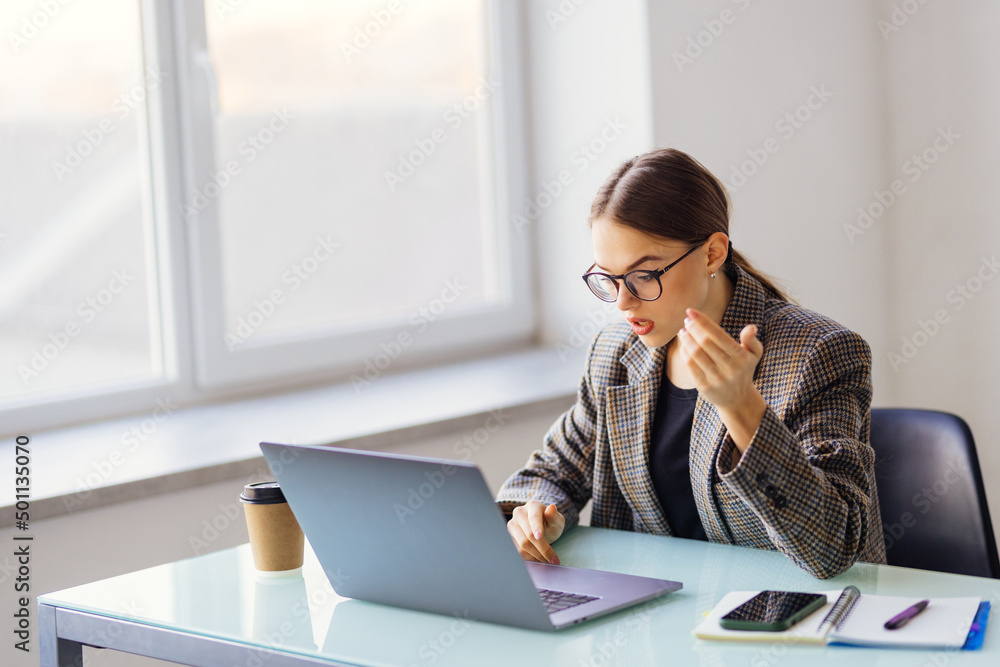 Young pretty woman having video call via laptop in the office Young pretty woman having video call via laptop in the office