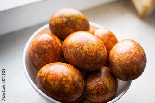 colored colorful chicken eggs in a large white plate as a symbol of the national holiday of believers