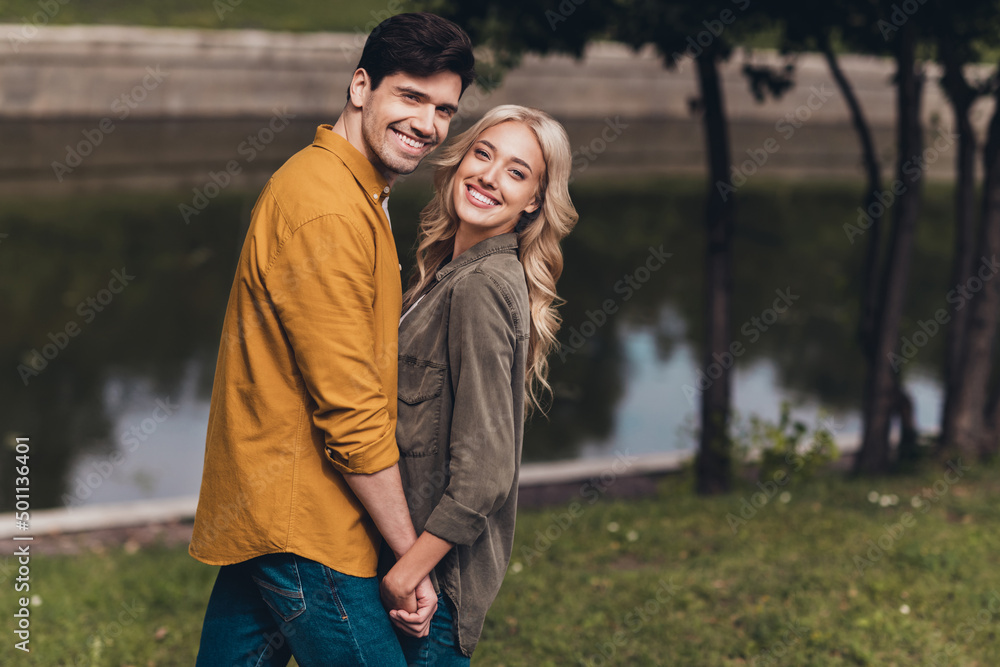 Profile side view portrait of cute cheerful couple life partners spending time cuddling enjoying on fresh air wood outdoors Profile side view portrait of cute cheerful couple life partners spending time cuddling enjoying on fresh air wood outdoors