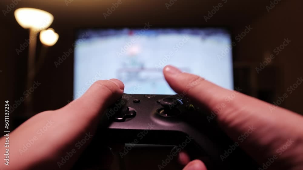 Man using controller playing hockey. Concept of video games. Close up of hands with joypad. Man using controller playing hockey. Concept of video games. Close up of hands with joypad.