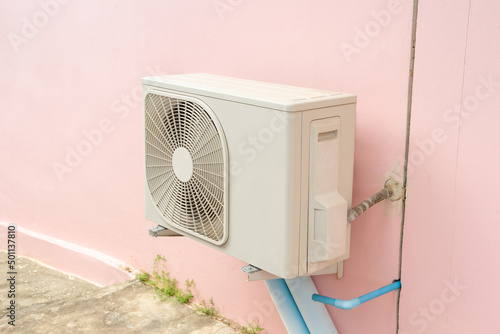 Condensing unit of air conditioning system. Condensing unit installed on wall.
