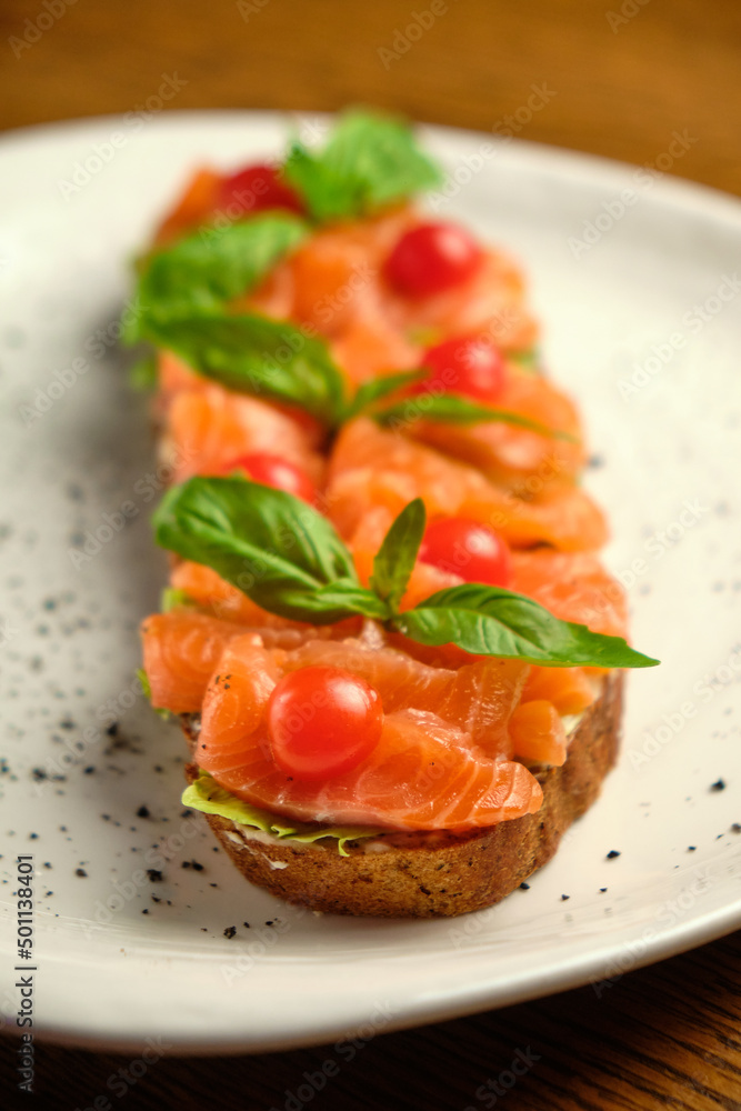 Bruschetta with pickled trout and salmon basil and tomatoes
