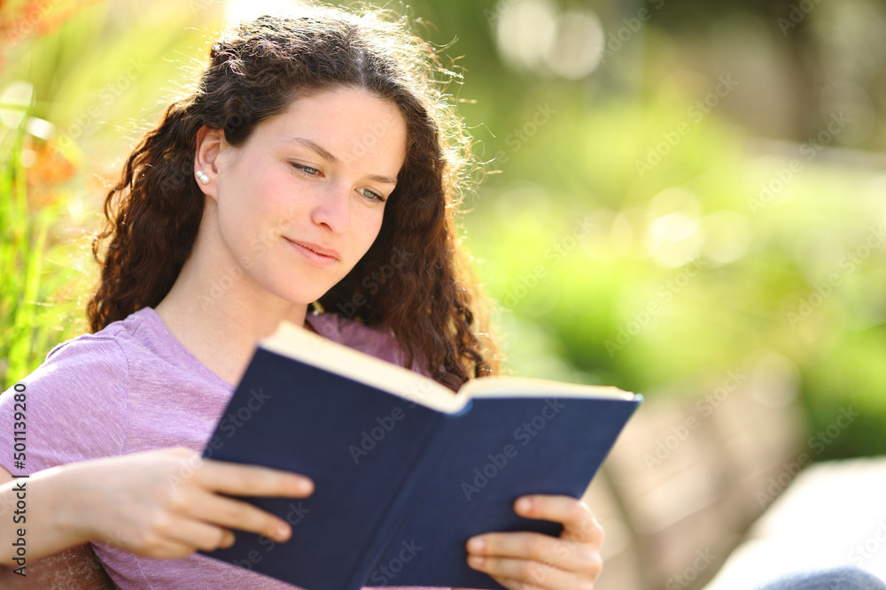 Relaxed woman reading a book in a beautiful park Relaxed woman reading a book in a beautiful park