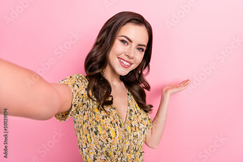 Photo of sweet millennial brunette lady hold empty space do selfie wear floral dress isolated on pink color background © deagreez