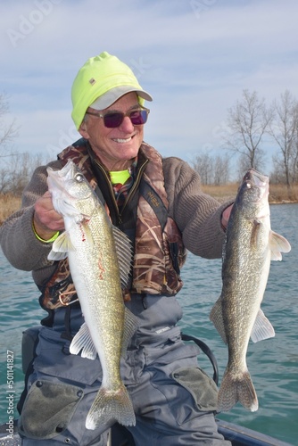 An angler with a pair of walleye 