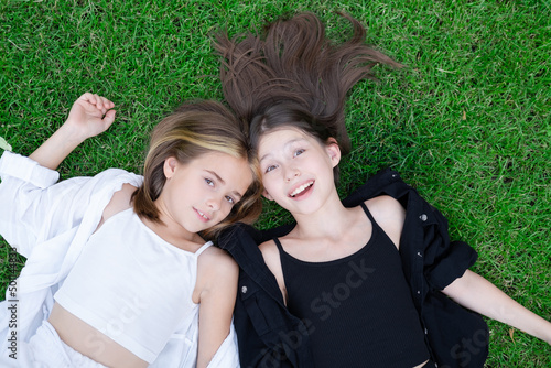 happy and lucky to have a sister. two girls outdoors in black and white clothes. good and bad. obedient and harmful. fraternal twins teen sisters.