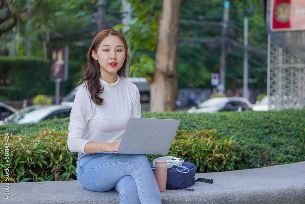 Asian students use laptops to study online via the Internet outside the home. outdoor learning and working concept Asian students use laptops to study online via the Internet outside the home. outdoor learning and working concept