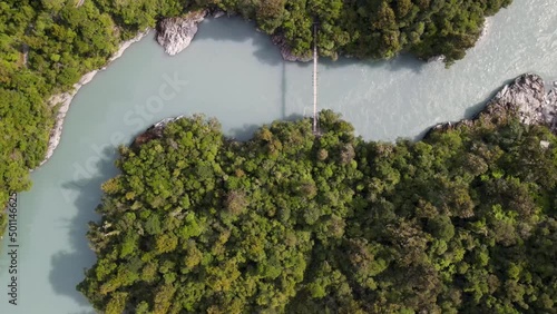 Colorful glacial Hokitika Gorge, rocky river bed, swing bridge. Popular track in lush green native New Zealand forest - aerial top down view photo