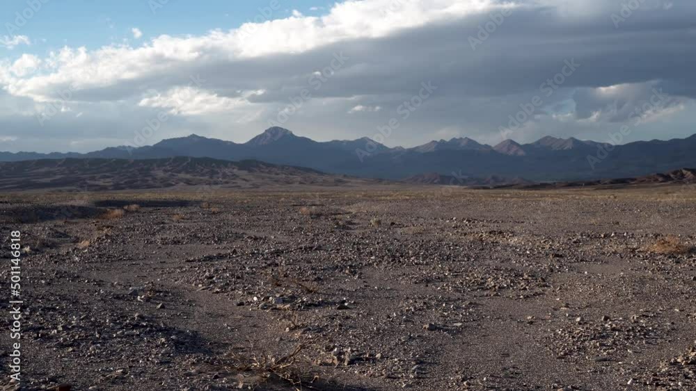 Mojave Desert arid gravel ground, California with Sierra Nevada in the distance, Aerial flyover low slow shot Mojave Desert arid gravel ground, California with Sierra Nevada in the distance, Aerial flyover low slow shot