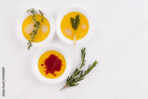 Olive oil with vinegar and herbs on white photo