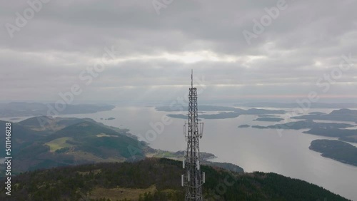 Top of mast tower antenna for transmitting wireless mobile 5G technology. Aerial orbit reveal scenic coastal in Norway.