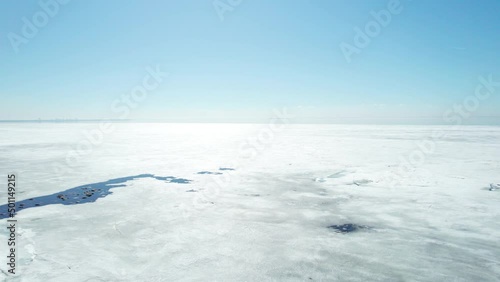 drone camera lift over frozen sea ocean sunny day blue sky summer spring ice jams. High quality 4k footage