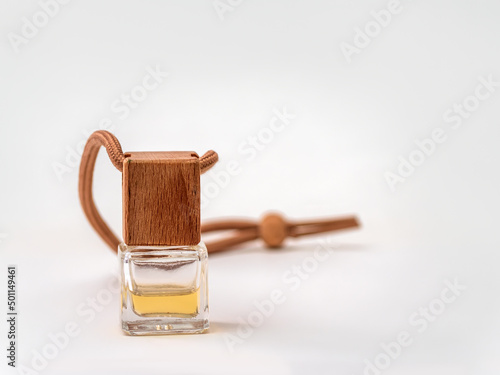 Car air-freshener on the white background. Small glass bottle filled of aromatic liquid. Close-up