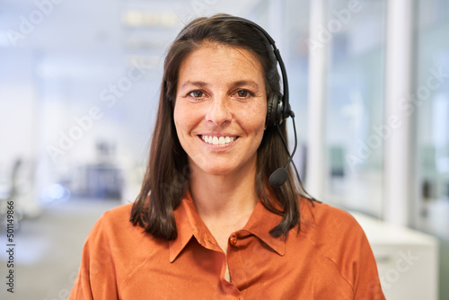 Glückliche Geschäftsfrau mit Headset als Kundenberater photo