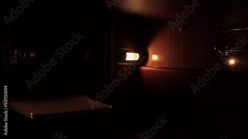 Inside compartment of corridor coach of railway passenger train at night. Light from luminaire is lit inside carriage. City lapms outside window. Empty russian railroad wagon. Travel tourism. Nobody photo