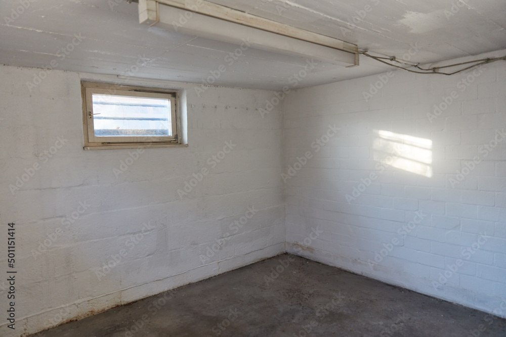 Fototapeta premium Ecke in einem leeren Kellerraum mit Fenster im Keller