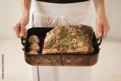 Chef Holding a Pan with Prime Rib Roast with Garlic