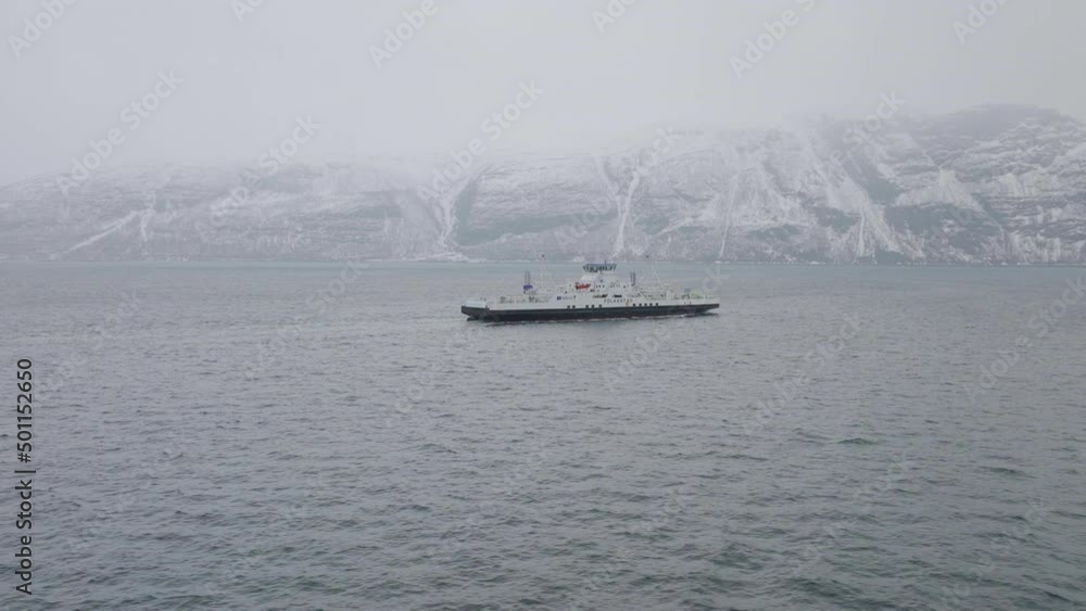 Drone shot orbiting a small ferry boat sailing on the coast of Norway Drone shot orbiting a small ferry boat sailing on the coast of Norway
