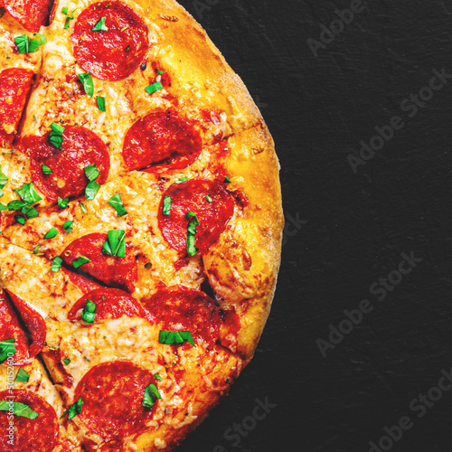 Pepperoni Pizza with cheese, salami, Tomato sauce, pepper, Spices. Italian pizza on black background