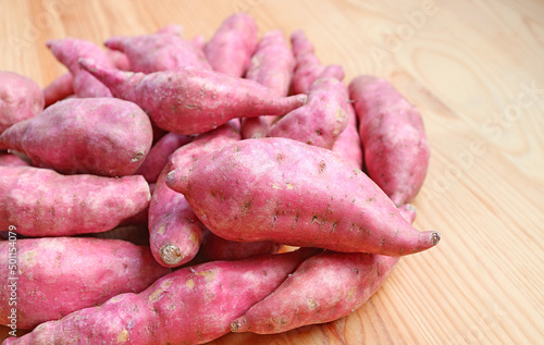 Heap of Raw Sweet Potatoes on Wooden Background