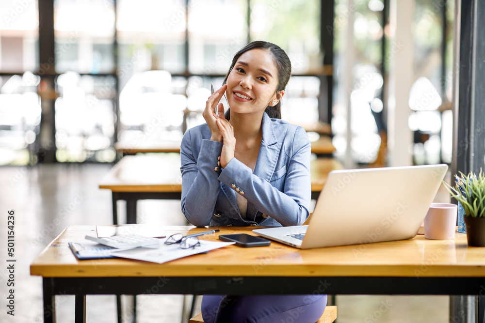 Portrait of happy Asian businesswoman looking at camera while working in office Portrait of happy Asian businesswoman looking at camera while working in office