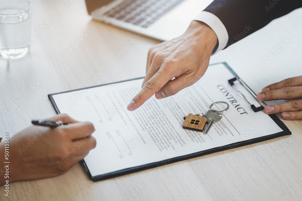 Businessman asking the client to sign contract document Businessman asking the client to sign contract document