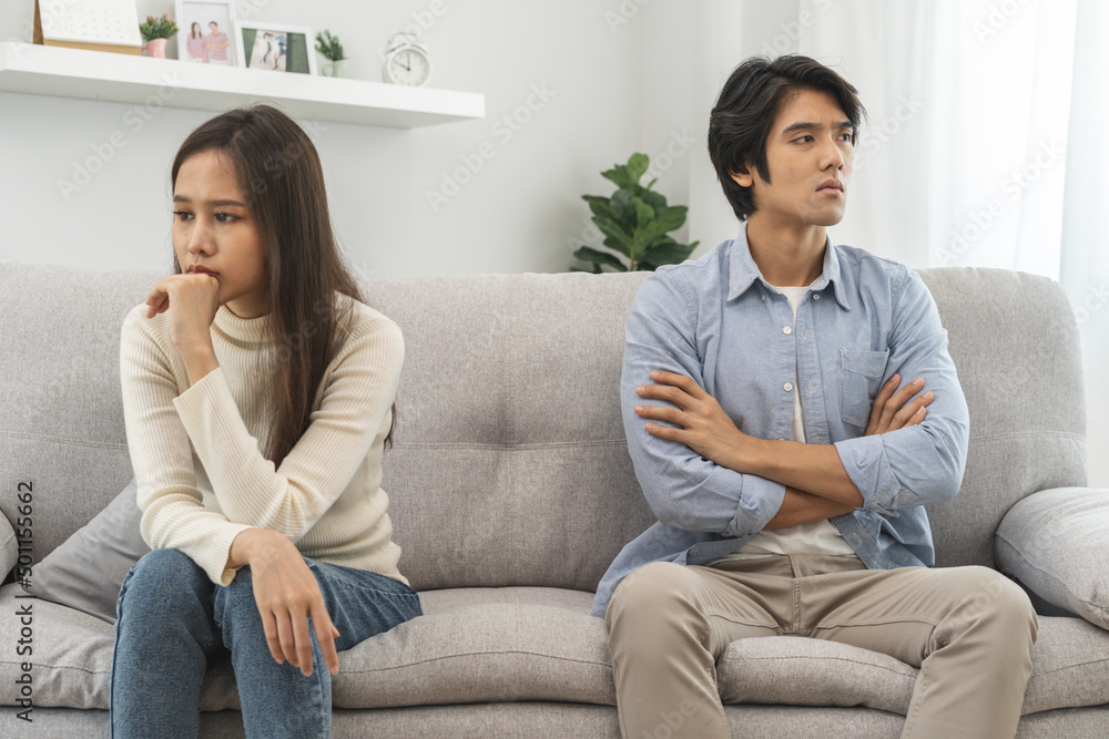 Family problems, Asian women cover her face and sit separately from husband feel disappointed after quarrels at home. Family problems, Asian women cover her face and sit separately from husband feel disappointed after quarrels at home.