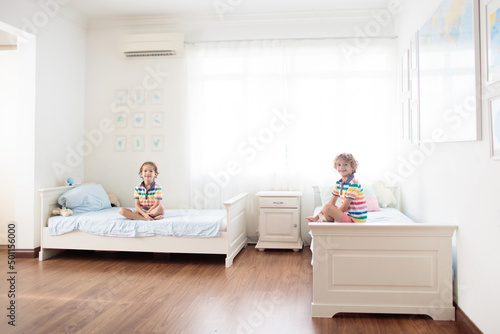 Child playing in bed. Kids room. Boy at home.