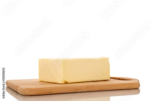One piece of delicious butter on a wooden cutting board, close-up, isolated on a white background.