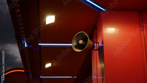 Public address loud speaker system for announcement at a carnival fairground in a theme park at night photo