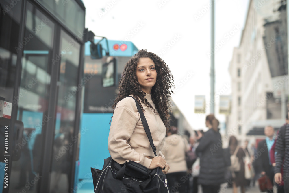 young woman with gym bag in street