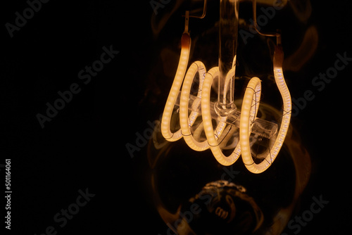 Fotobehang long tube-shaped Edison lamp, bulb, black background.