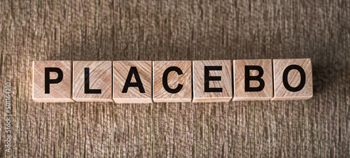 Placebo word written on blocks on wooden surface. Placebo effect, fake medical treatment photo