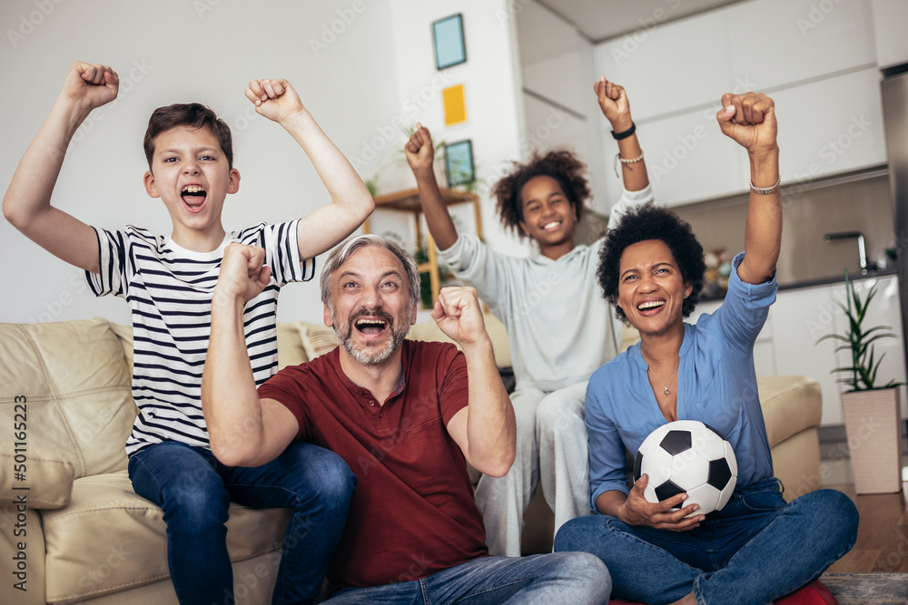 Excited family football fans watching sport tv game celebrating goal together