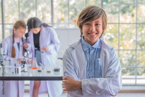 male student studying science class standing in front of class