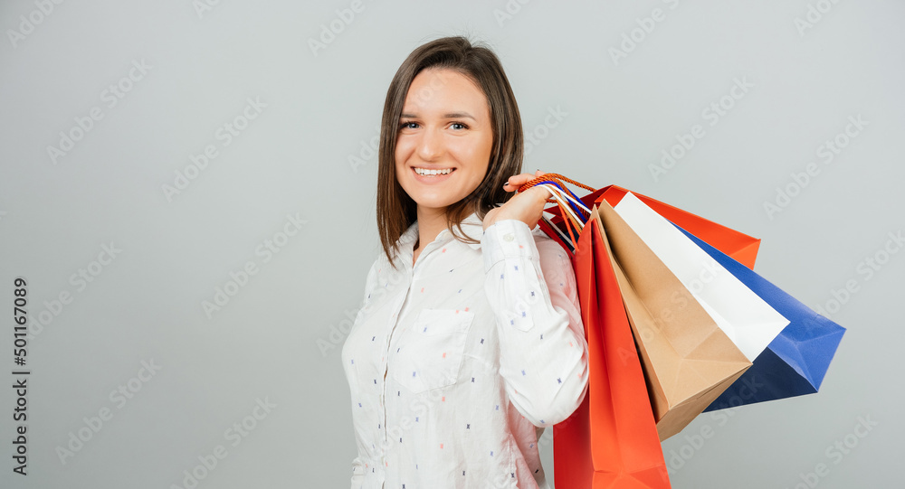 Portrait of happy young woman smiling at the camera and holding many shopping bags Portrait of happy young woman smiling at the camera and holding many shopping bags