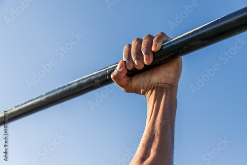 Calisthenics. Hands on bar. Outdoor training and working out.