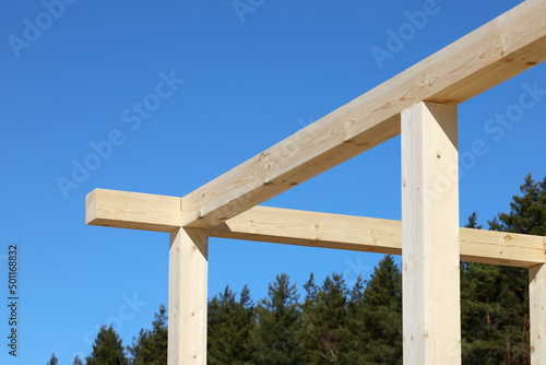 Wooden beams of construction structure, on background of blue sky 