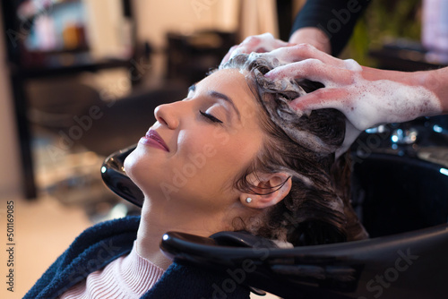 Hairdresser washing hair of the woman in modern hair salon