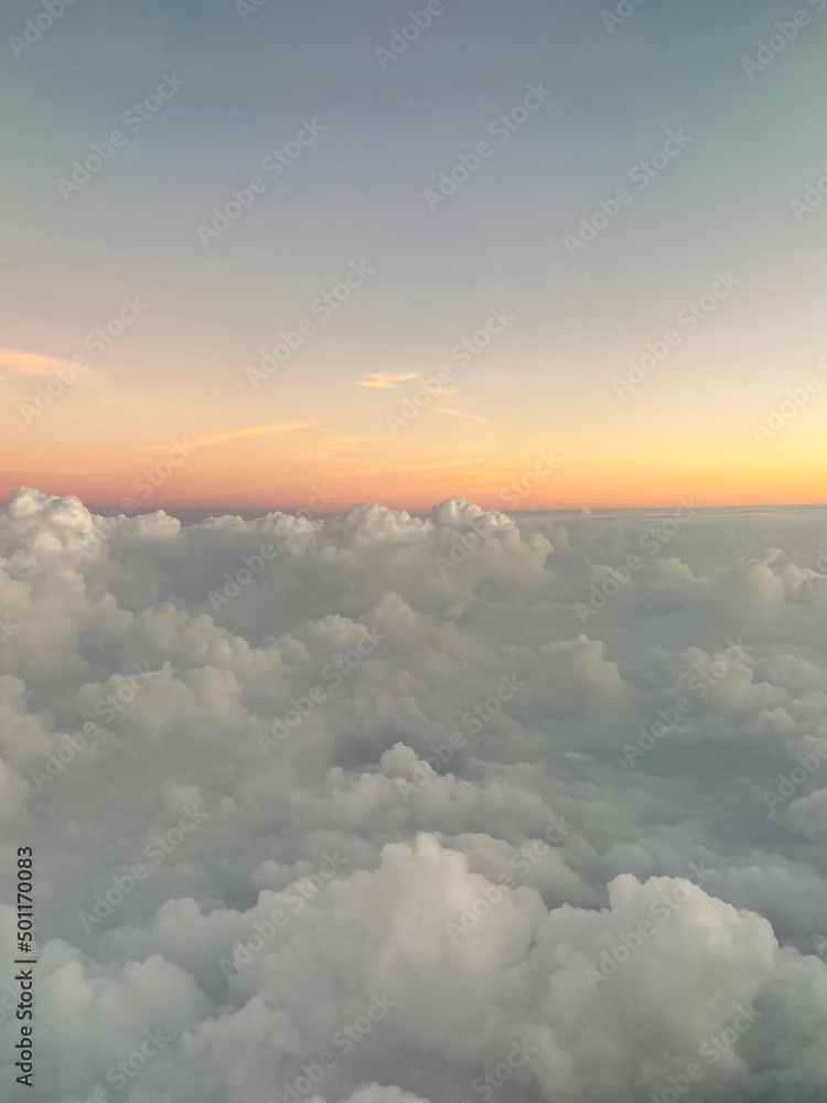 Obraz premium Early Morning Sunrise and Cumulus Clouds from an Airplane Window