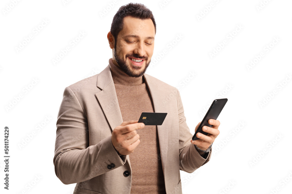Young man looking at a credit card and holding a mobile phone Young man looking at a credit card and holding a mobile phone