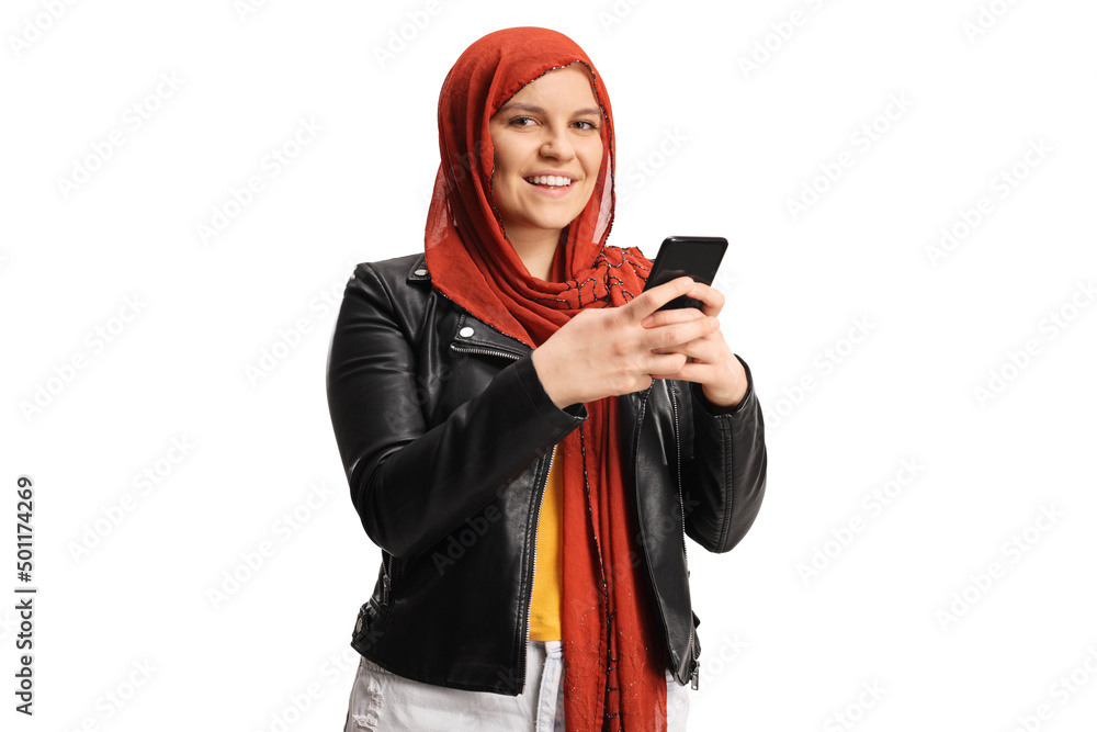 Young female with a hijab typing on a smartphone and looking at camera Young female with a hijab typing on a smartphone and looking at camera