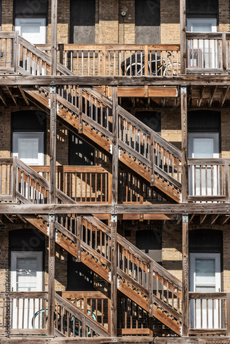 Urban apartment multi-unit dwelling with side-by-side units stacked on top of each other separated by a wood frame. © jetcityimage