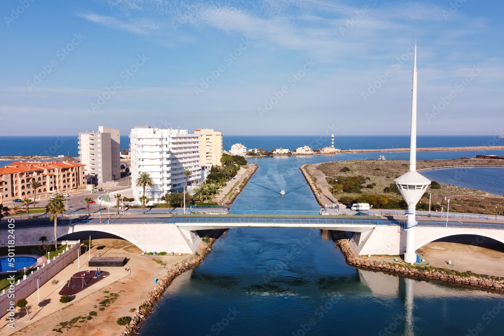 Bird's eye view of a shipping canal and a drawbridge in a tourist region in southern spain.