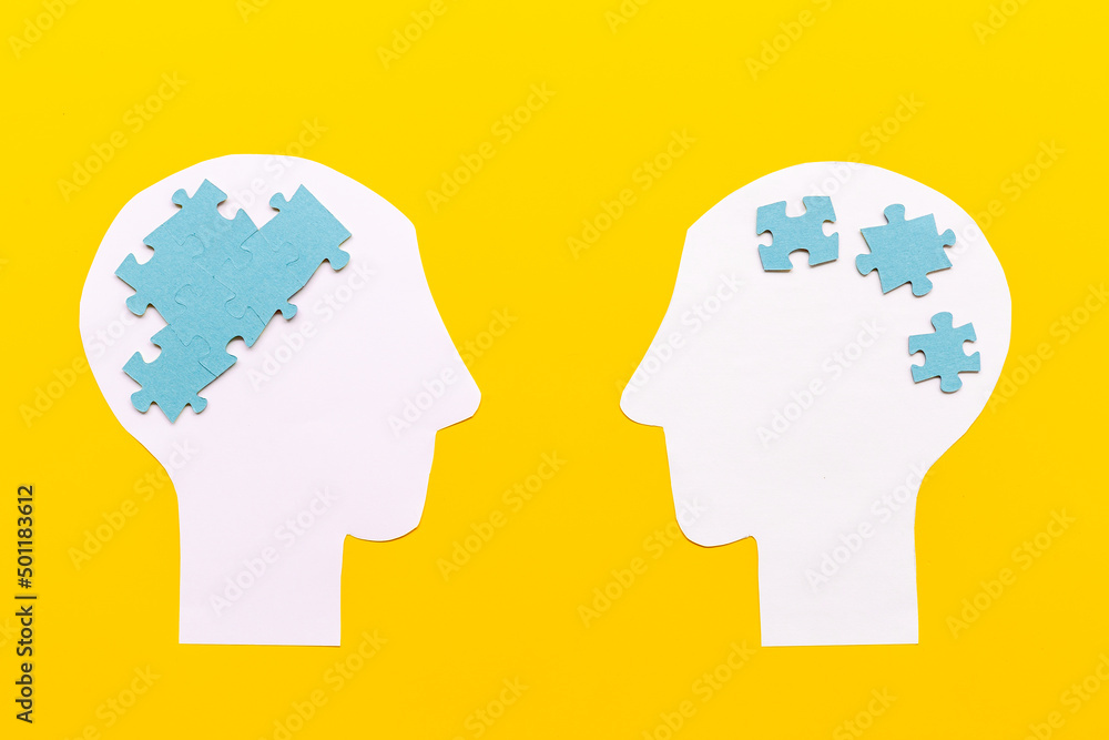 Communication. Chaos and peace in brain - two paper human heads with puzzles