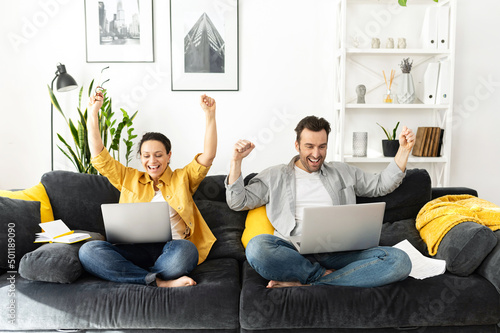 Φωτογραφία Woman and her man in front of laptop, rejoicing at their success