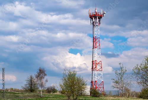Telecommunication tower of 4G and 5G cellular. Macro Base Station. 5G radio network telecommunication equipment with radio modules and smart antennas mounted on a metal against cloulds sky background.
