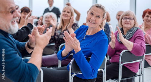 a group of elderly people are sitting in a circle clapping their